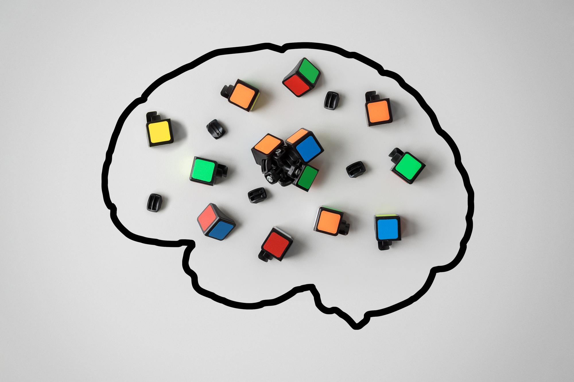 Concept of mental health. Silhouette of a human brain with a broken conundrum on a gray background.