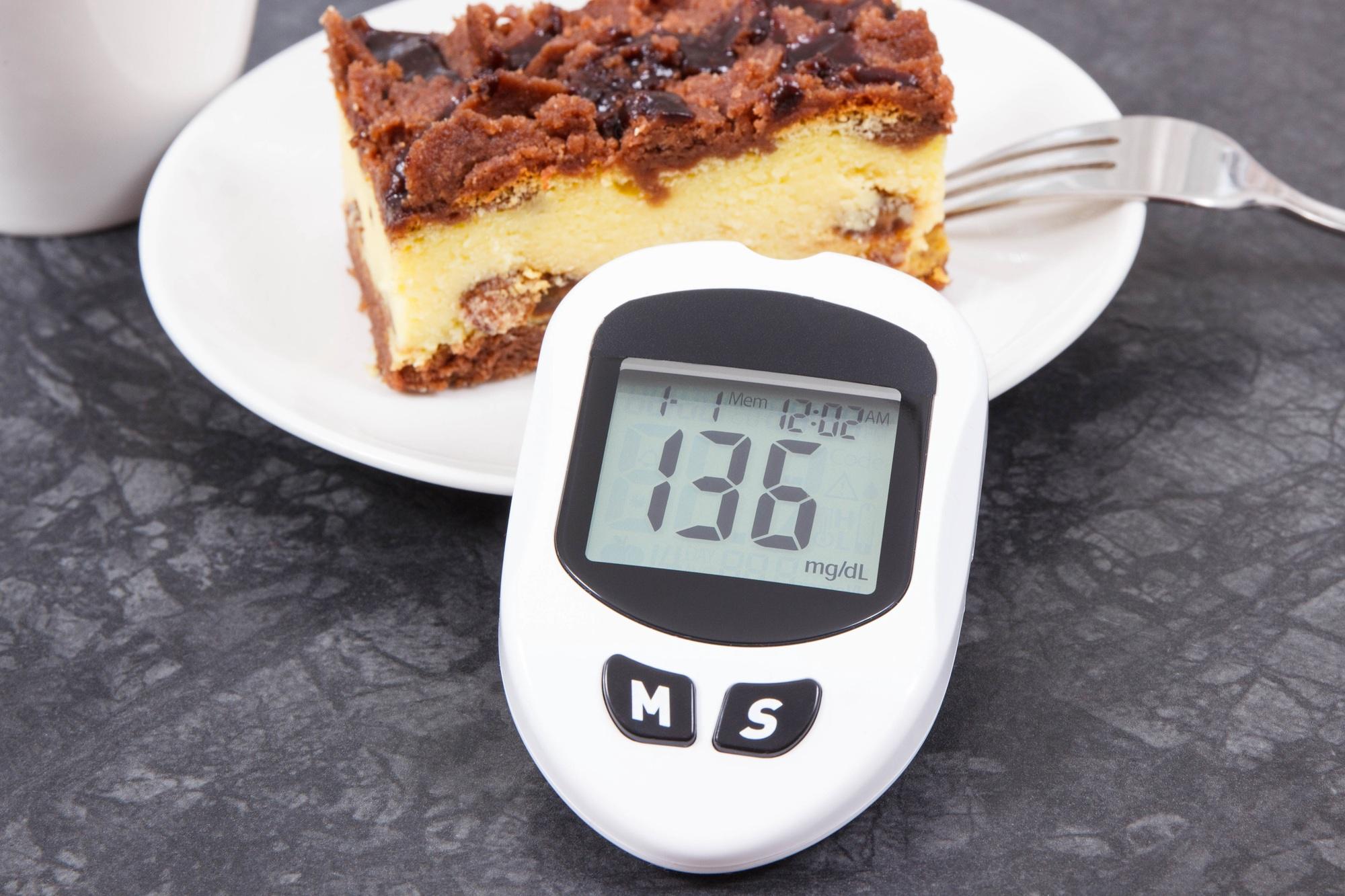 Glucometer for checking sugar level and fresh baked cheesecake. Diabetes and dieting during diabetes