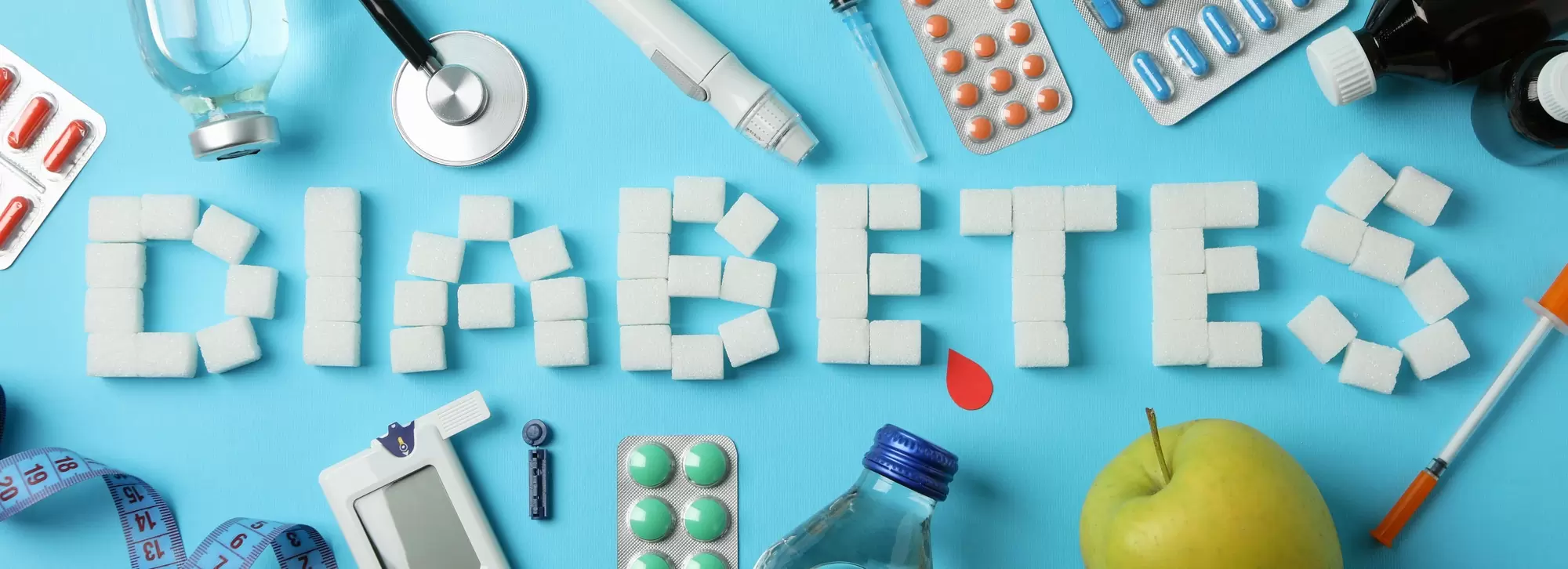 Word Diabetes made of sugar cubes on blue background. Diabetes accessories