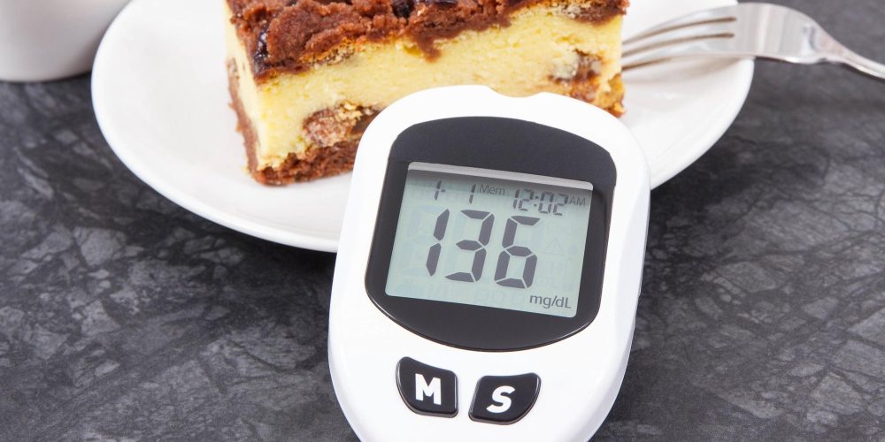 Glucometer for checking sugar level and fresh baked cheesecake. Diabetes and dieting during diabetes