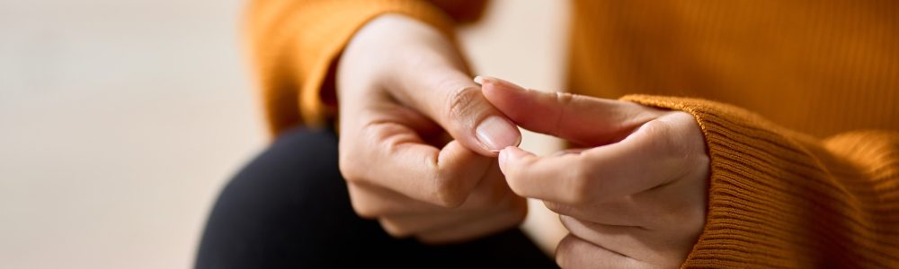 Hands of a woman playing with nails in stress
