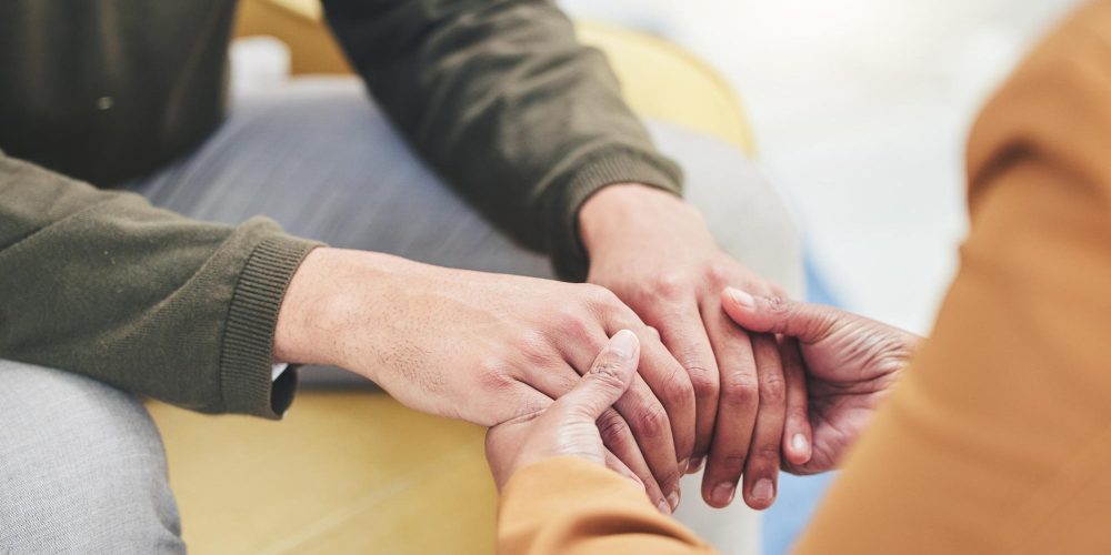 Mental health, support and patient holding hands with therapist in counseling session for depressio