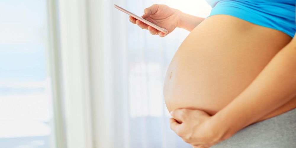 Shes got her obgyn on speed dial. Cropped shot of a pregnant woman using a mobile phone at home.