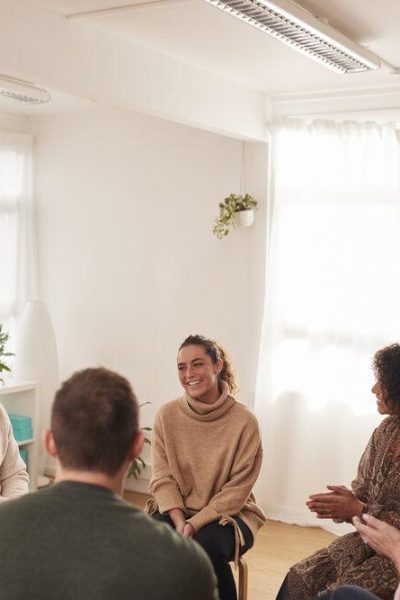 Woman Speaking At Support Group Meeting For Mental Health Or Dependency Issues In Community Space